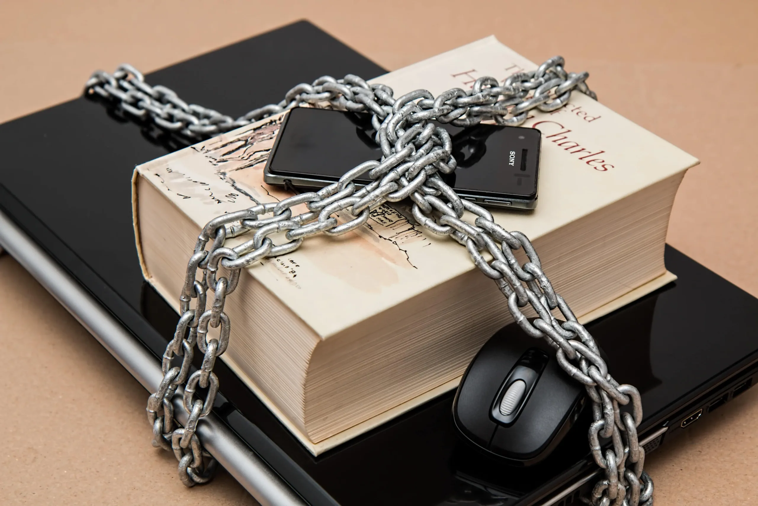 Mobile phone, Book and Laptop are locked in chain showing data security
